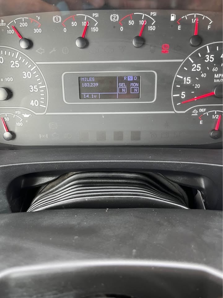 Close-up of a vehicle dashboard displaying odometer reading of 150,239 miles with speedometer, fuel gauge, and digital display screen visible